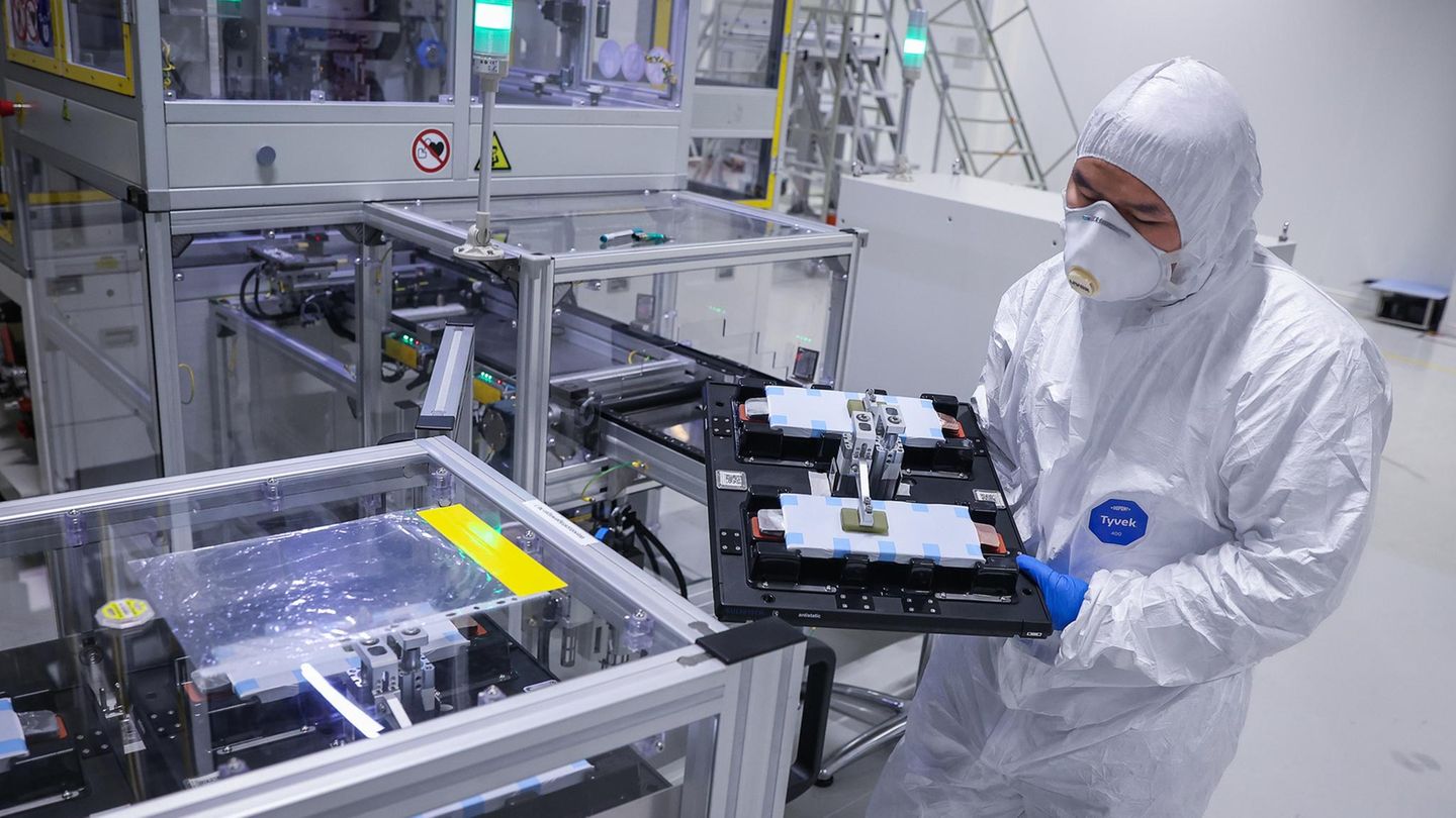 Staub: Fabrikarbeiter mit weißem Anzug und Staubmaske