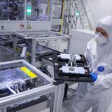 Staub: Fabrikarbeiter mit weißem Anzug und Staubmaske