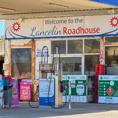 Gasflaschen und Werbetafeln an einer abgelegenen Tankstelle im Westen Australiens