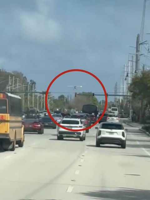 Ein Mann nimmt eine Flugzeug-Notlandung auf einer Straße vor.