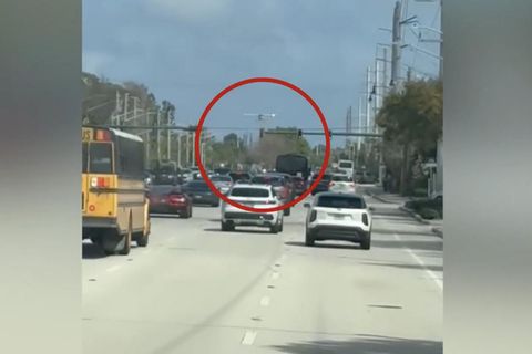 Ein Mann nimmt eine Flugzeug-Notlandung auf einer Straße vor.