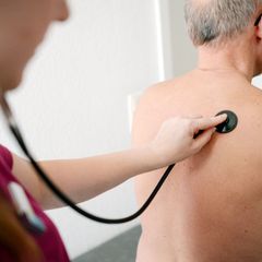 Eine Hausärztin untersucht einen Patienten mit einem Stethoskop. (Archivbild) Foto: Maurizio Gambarini/dpa