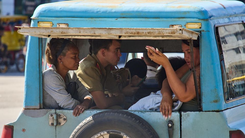 Kubaner teilen sich die Ladefläche eines Autos