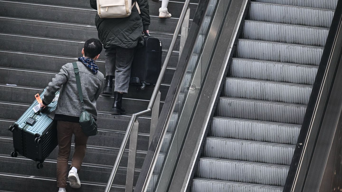 Fahrgäste tragen ihre Koffer am Berliner Hauptbahnhof über die Treppe. (Archivbild) Foto: Britta Pedersen/dpa