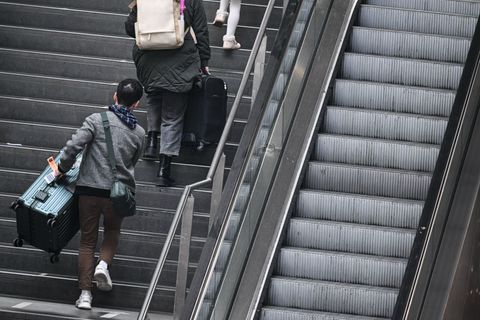 Fahrgäste tragen ihre Koffer am Berliner Hauptbahnhof über die Treppe. (Archivbild) Foto: Britta Pedersen/dpa