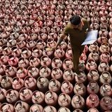 Amritsar, Indien. Ein Arbeiter inspiziert Flüssiggasflaschen, die zur Auslieferung an Kunden in einem Vertriebszentrum am Stadtrand bereitstehen. Hoffentlich muss er sie nicht auch zählen, denn das könnte dauern. Vor allem, wenn er sich verzählt.