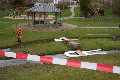 Ein Arbeiter pumpt mit Hilfe einer Ölsperre das durch Diesel verunreinigte Wasser aus dem Bach ab. Foto: Thomas Frey/dpa