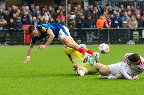 Kiels Adrian Kapralik (l) prallt mit Nürnbergs Jan Reichert zusammen. Foto: Frank Molter/dpa