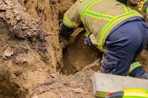 Feuerwehrleute befreien Terrier Janosch aus einem Dachsbau. Foto: Freiweillige Feuerwehr Wachtberg/dpa