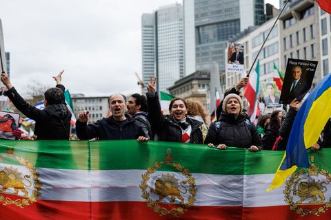 Teilnehmer halten Flaggen der iranischen Monarchie bei einer Demonstration in Frankfurt in die Höhe. Foto: Hannes P Albert/dpa