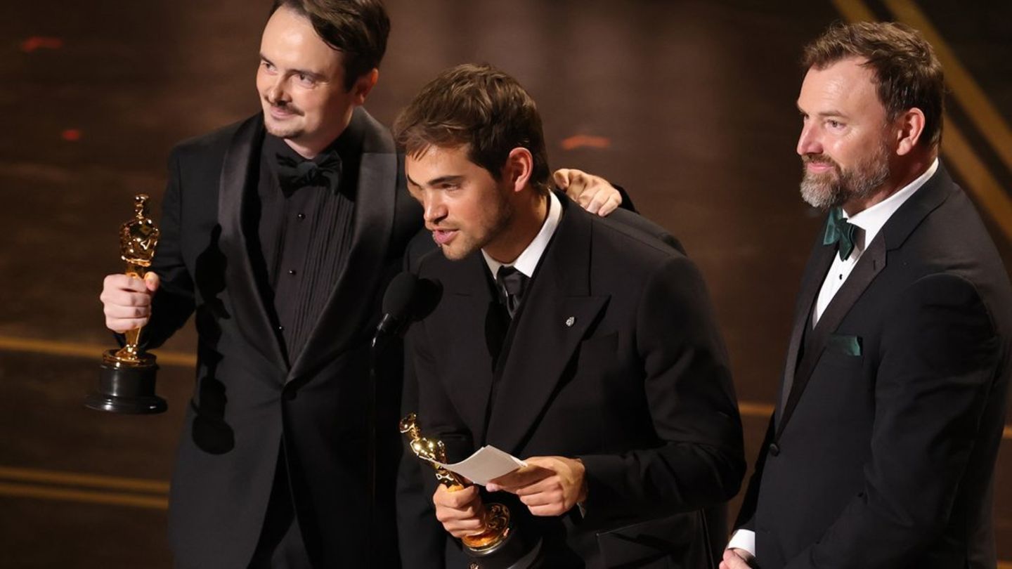 David Breschel, Sam A. Davis und Jack Piatt nehmen ihre Oscar-Statuetten für "The Singers" in Empfang.