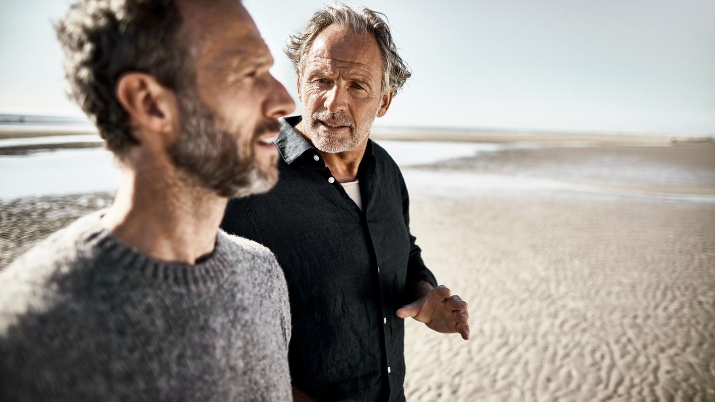 Zwei Männer unterhalten sich über das Leben bei einem Strandspaziergang, nicht abgebildet ist Sina Haghiri