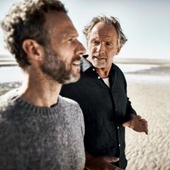 Zwei Männer unterhalten sich über das Leben bei einem Strandspaziergang, nicht abgebildet ist Sina Haghiri