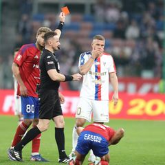 Der Gegenspieler krümmt sich am Boden und Lukas Podolski sieht die Rote Karte