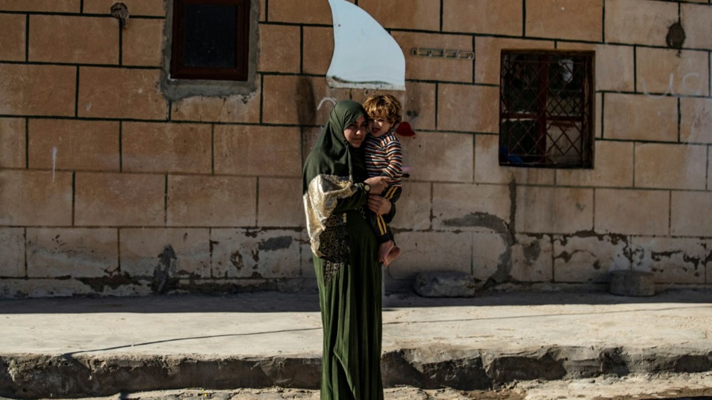 Jesidin mit Kind auf dem Arm