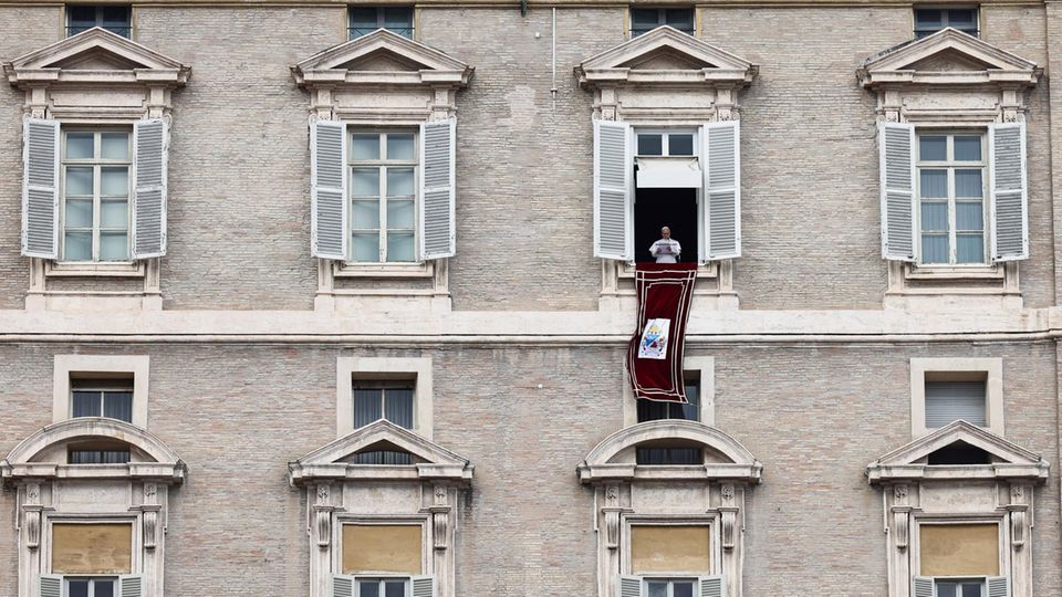 Papst Leo XIV. steht am Fenster seines Ateliers mit Blick auf den Petersplatz im Vatikan, wo sich katholische Gläubige und Pilger zum traditionellen Sonntagssegen am Ende des Angelusgebets versammelt haben