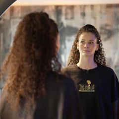 Betty Taube guckt in einen Spiegel.