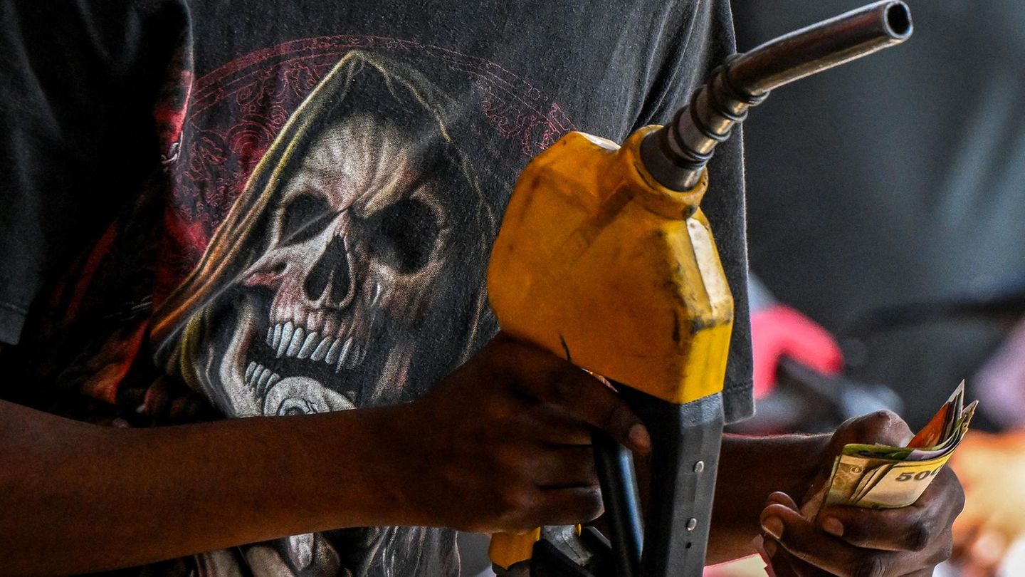 Mitarbeiter einer Tankstelle mit Totenkopf auf dem T-Shirt