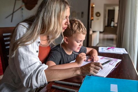 Hilfe bei den Hausgaben: Eine Mutter sitzt mit ihrem Sohn am Schreibtisch