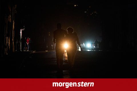 Kuba, Havanna: Menschen überqueren eine Straße während eines Stromausfalls in Havanna.