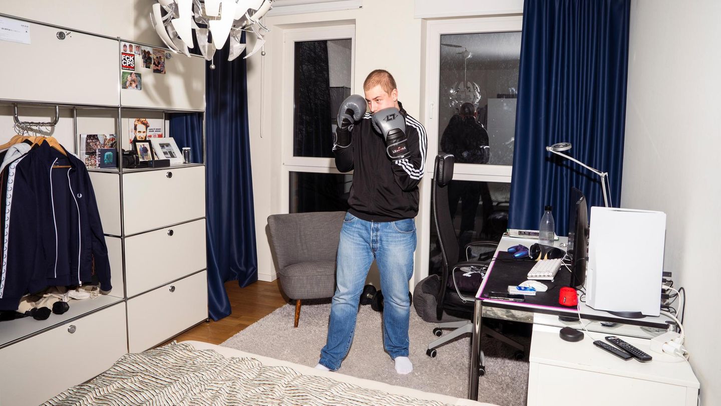 Wehrdienst: Ein Teenager steht in seinem Zimmer mit angezogenen Boxhandschuhen