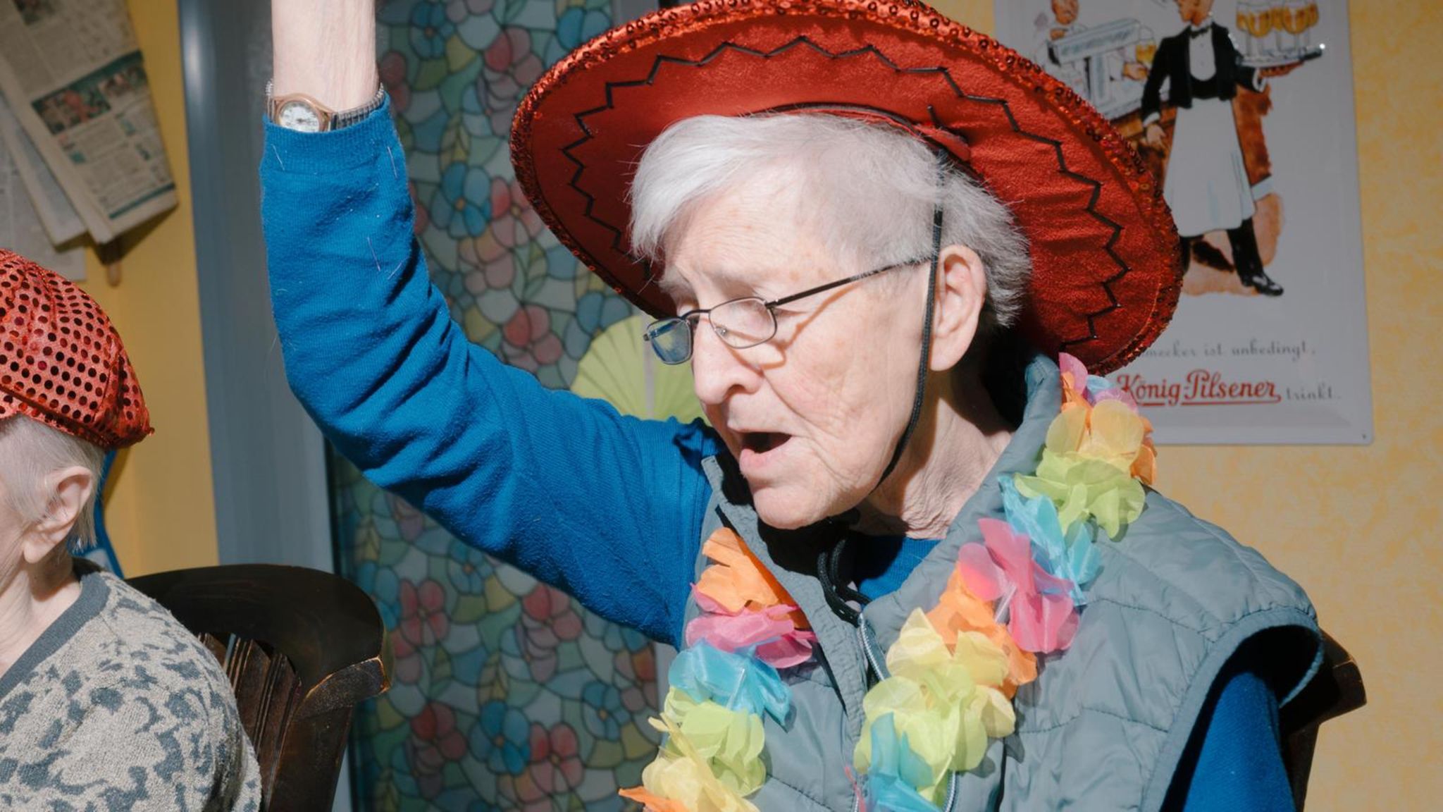 Bewohnerin feiert in einer Kneipe für Menschen mit Demenz