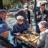 Eine Gruppe älterer Herren spielt Schach im Park