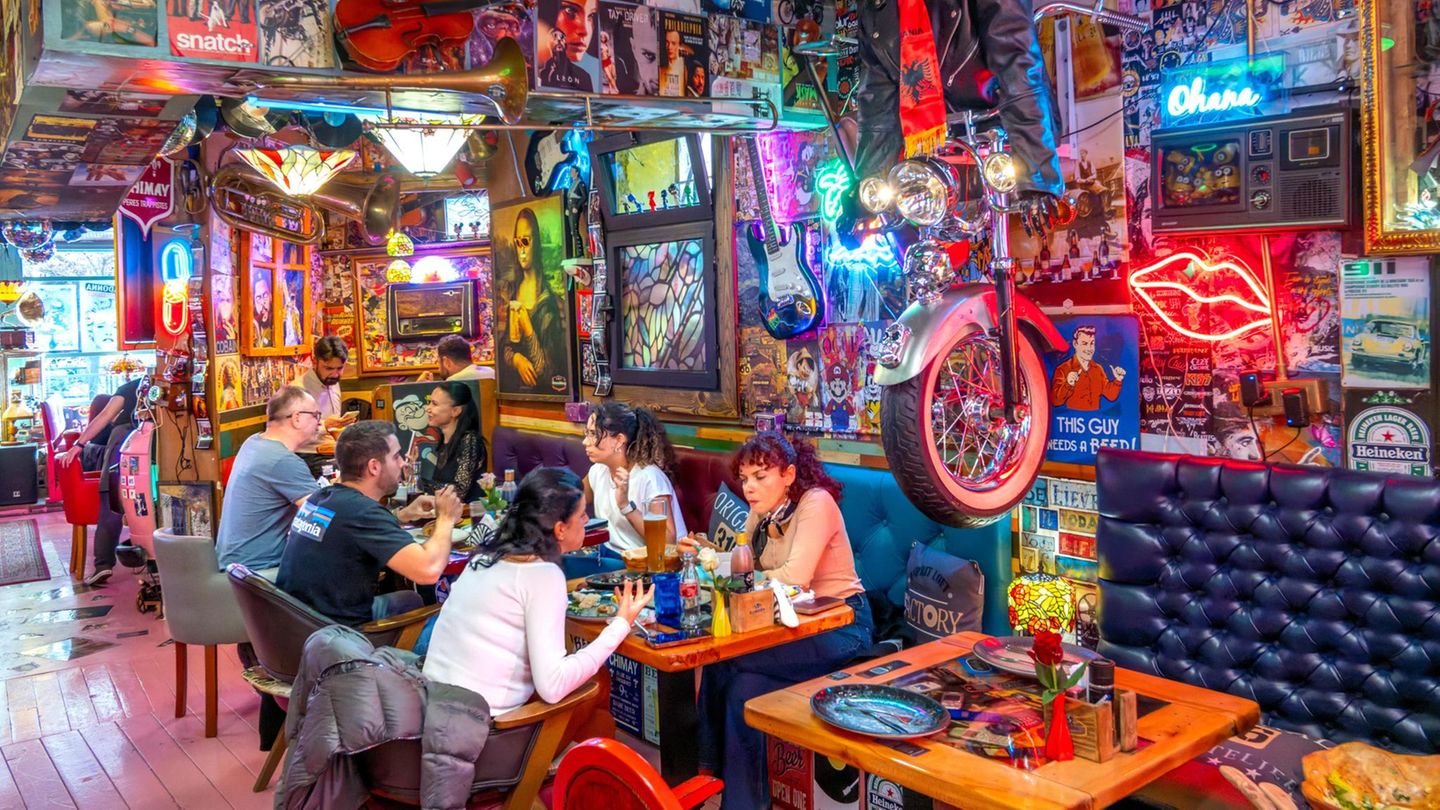 Knallbuntes Restaurant, Menschen sitzen an Tischen und essen