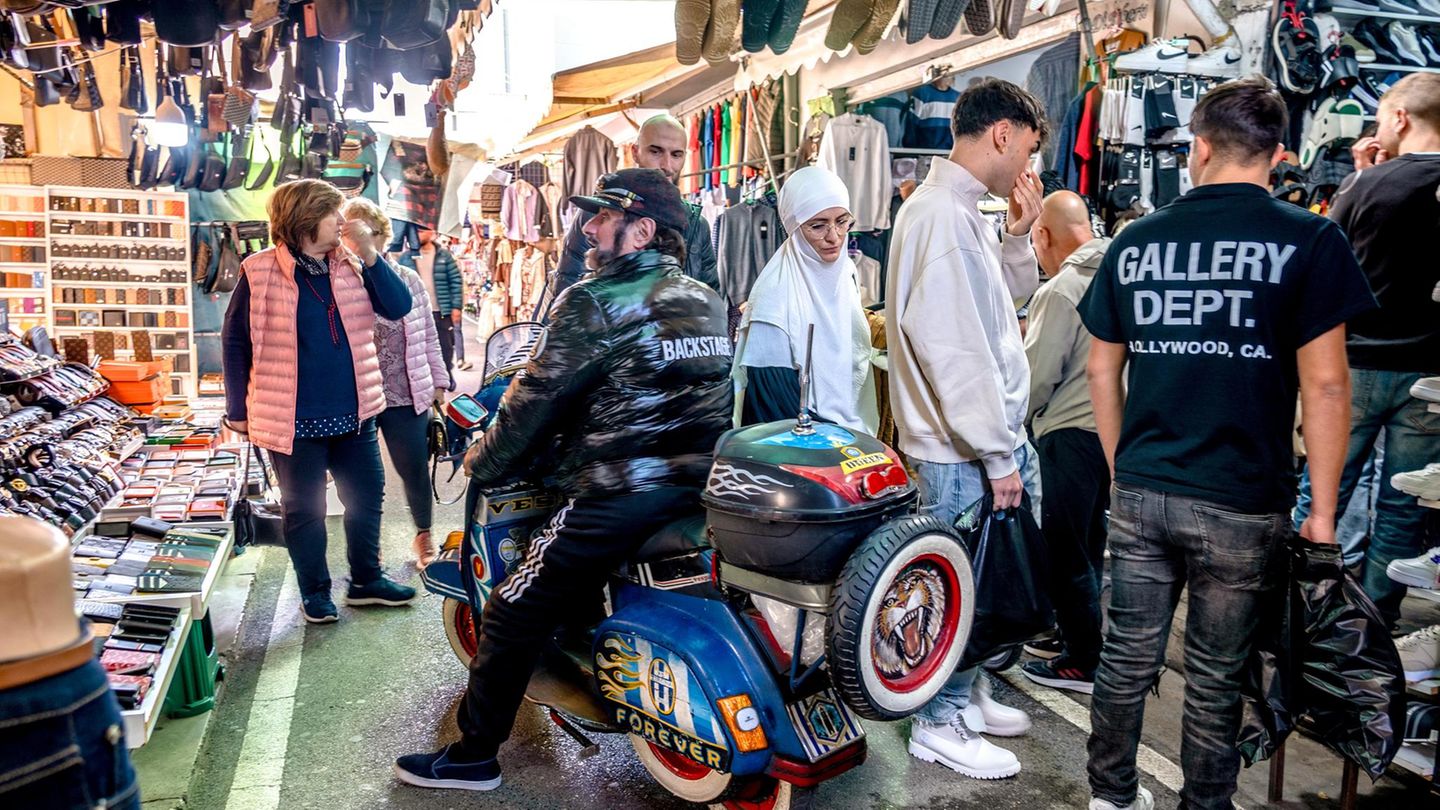 Ein Mopedfahrer hält kurz in den engen Gassen des Straßenmarktes von Tirana