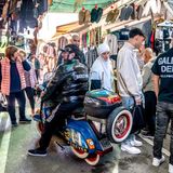 Ein Mopedfahrer hält kurz in den engen Gassen des Straßenmarktes von Tirana