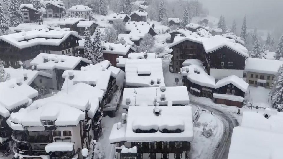 Ein Alpendorf in Italien ist von Schnee bedeckt.