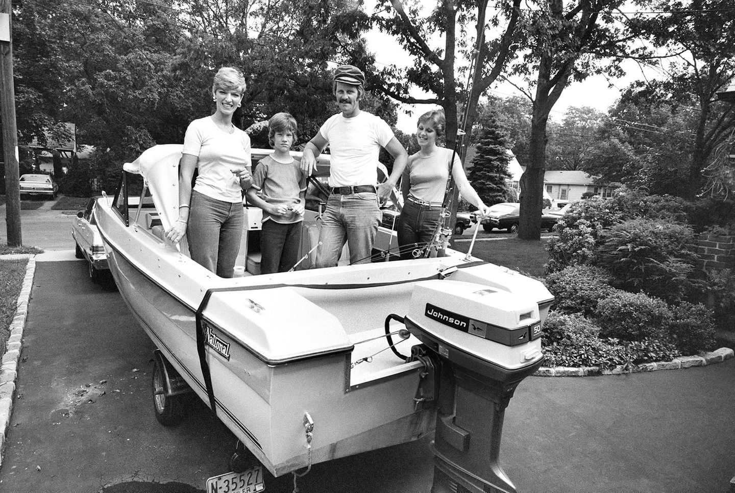 Ein Polizist steht mit Frau und zwei Kindern in einem Boot mit Außenbordmotor