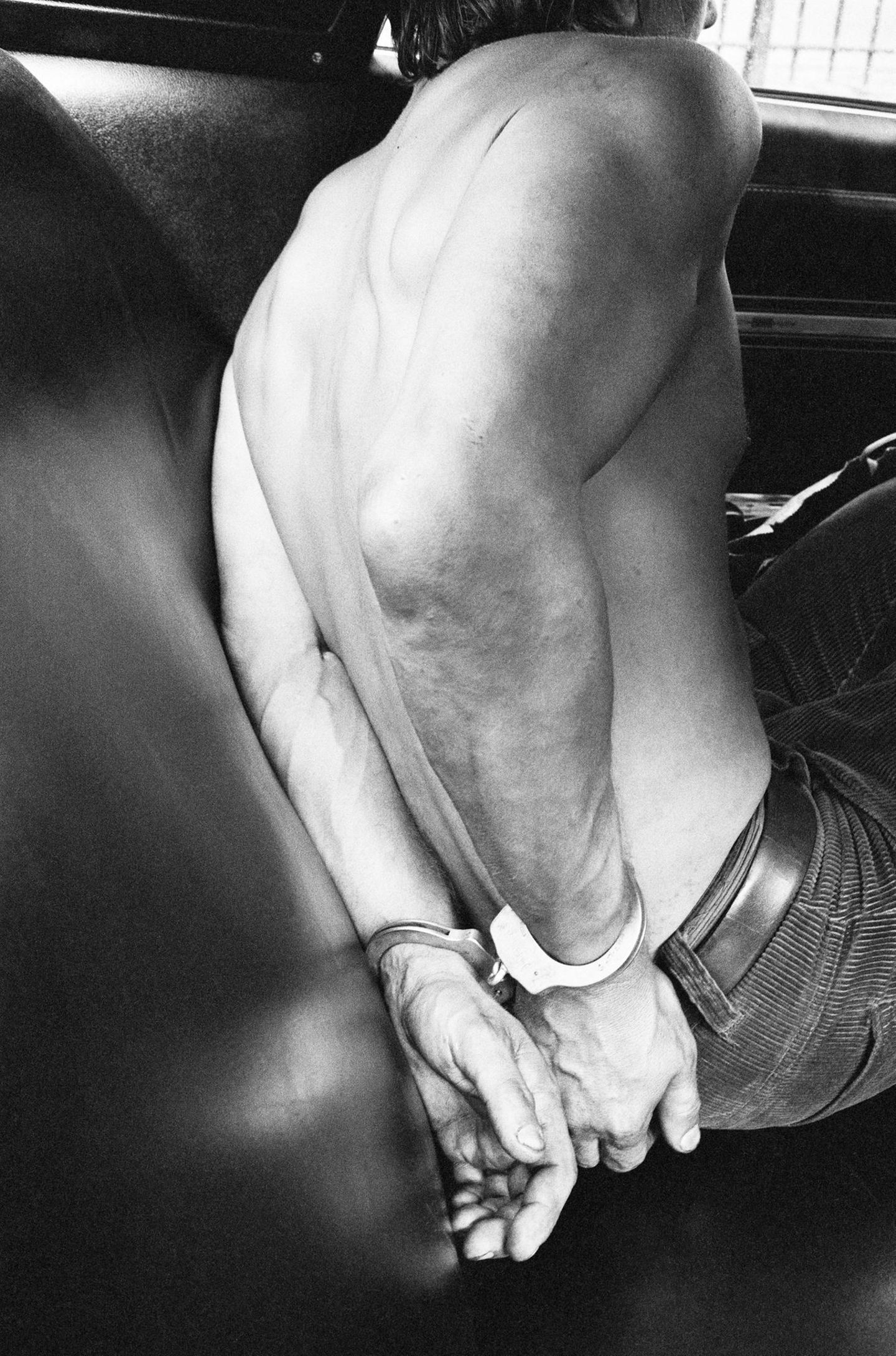 Ein Mann in Handschellen auf dem Rücksitz eines Polizeiautos