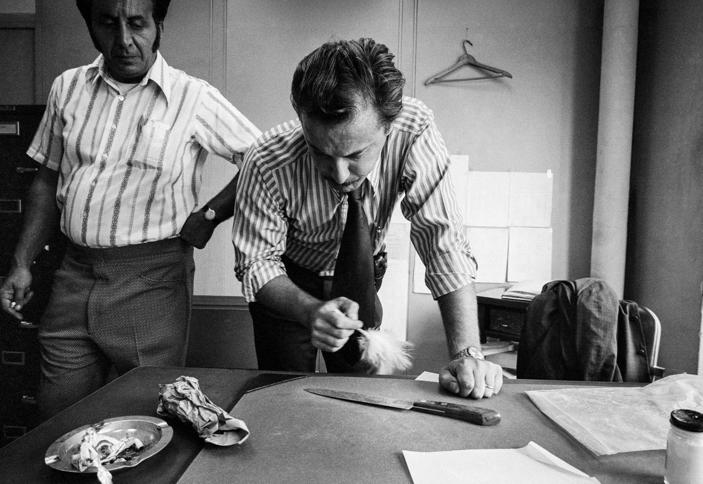 Ein Ermittler pudert ein Messer ab