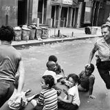 Eine Polizistin spielt mit Kindern auf der Straße