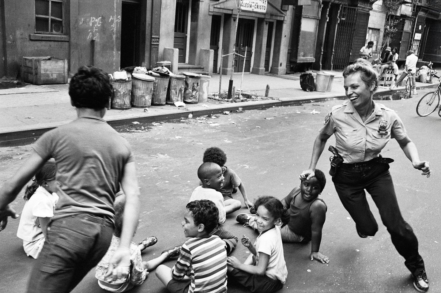 Eine Polizistin spielt mit Kindern auf der Straße