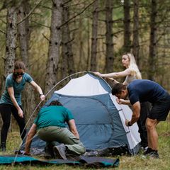 Deals des Tages: Vier junge Menschen bauen ein Kuppelzelt auf