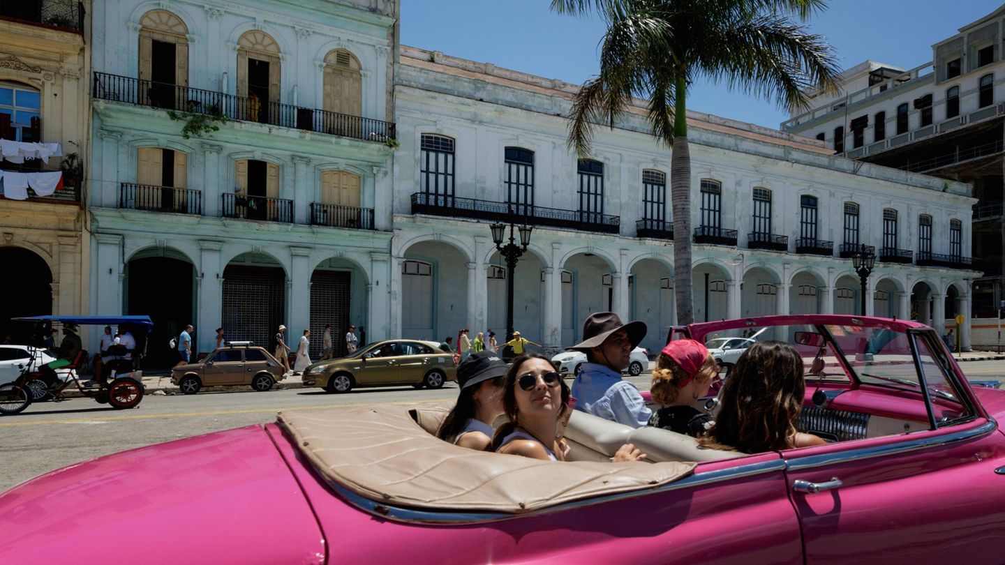 Touristinnen fahren in Havana mit einem Cabrio durch die Stadt
