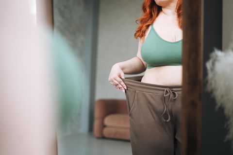 Frau trägt Übergroße Hose, zeigt Gewichtsverlust