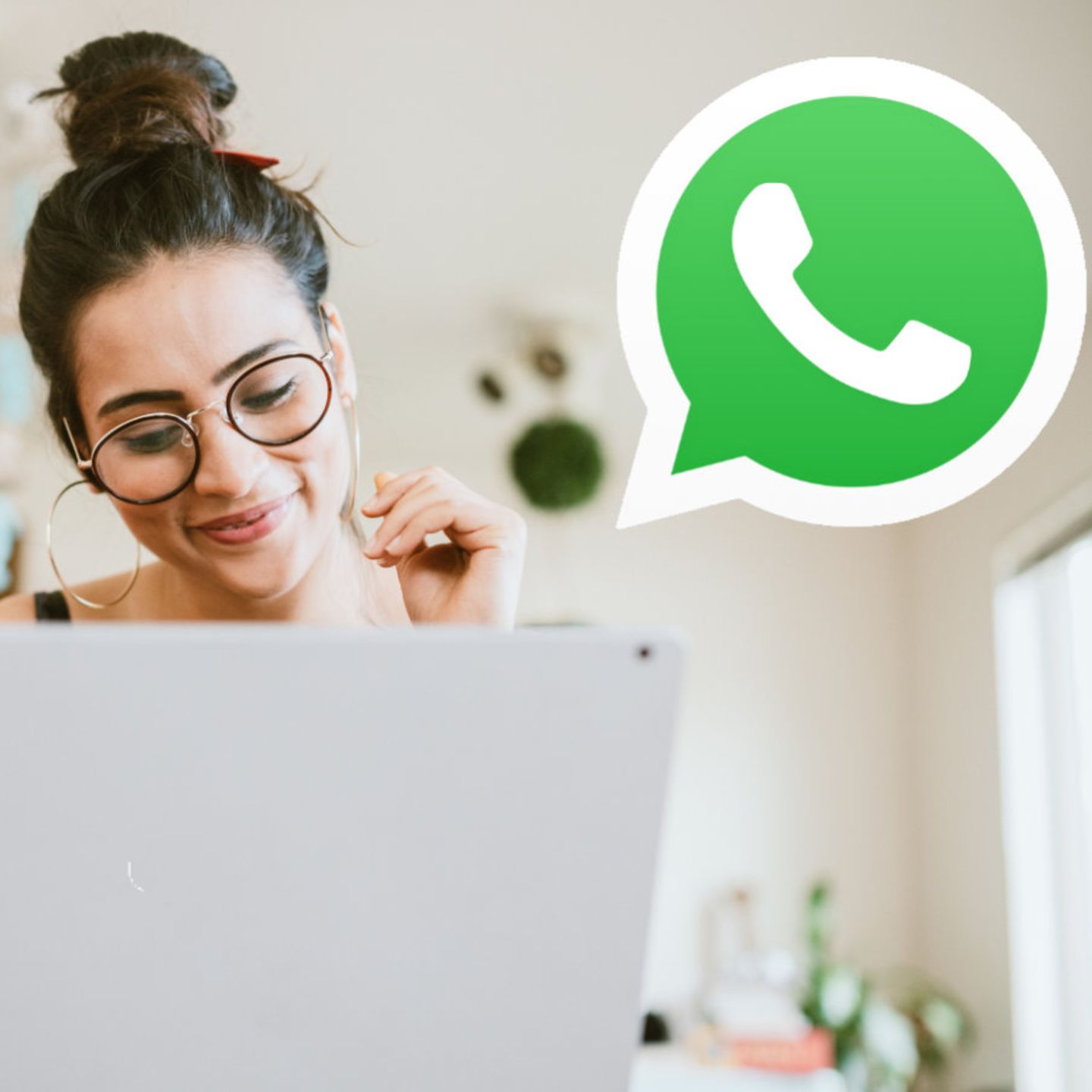 Eine Frau sitzt am Rechner, rechts von ihr ist das Whatsapp-Symbol zu sehen