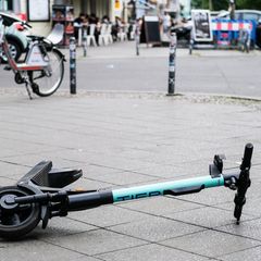E-Scootern liegt umgekippt mitten auf dem Bürgersteig