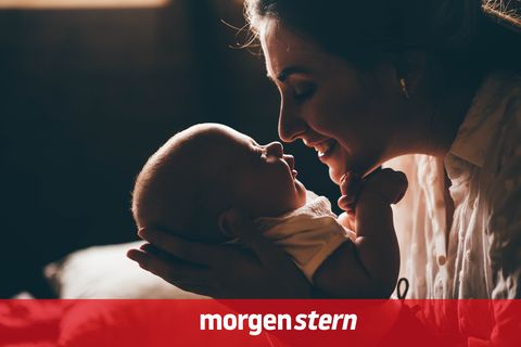 Mutter lächelt ihr Neugeborenes an – Kindergeld muss sie ab 2027 nicht mehr beantragen