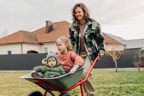 Familie im Garten vor Haus
