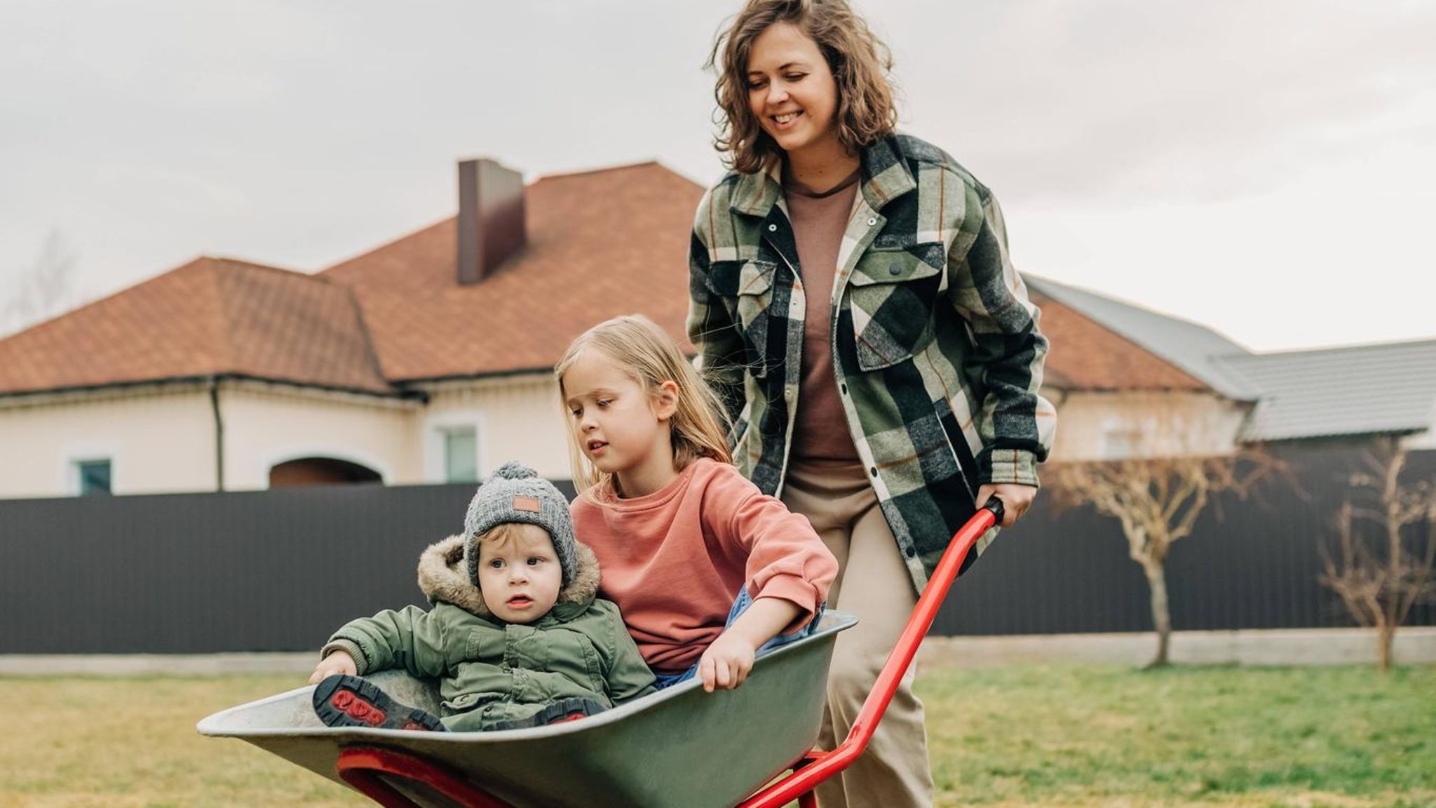 Familie im Garten vor Haus