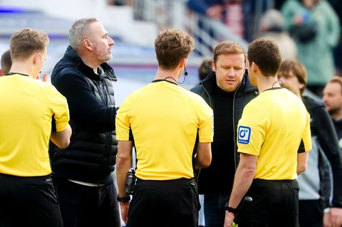 Kiels Trainer Tim Walter (2.v.l.) und Kiels Geschäftsführer Sport Olaf Rebbe (2.v.r.) unterhalten sich mit dem Schiedsrichterges