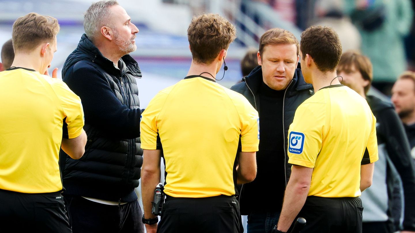 Kiels Trainer Tim Walter (2.v.l.) und Kiels Geschäftsführer Sport Olaf Rebbe (2.v.r.) unterhalten sich mit dem Schiedsrichterges