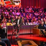 Jan Ullrich fährt auf einem Fahrrad durch ein TV-Studio