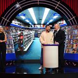 Edin Hasanovi steht mit Barbara Schöneberger und Stefan Raab vor der Kulisse einer Videothek