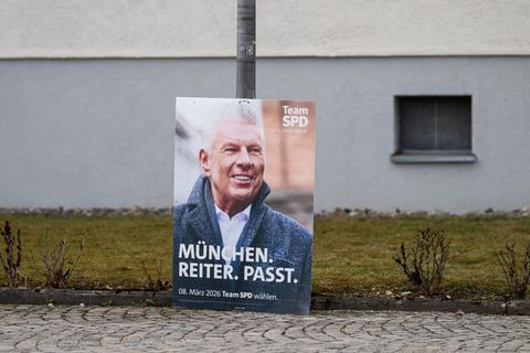 Ein Plakat von OB Dieter Reiter lehnt an einem Laternenmast
