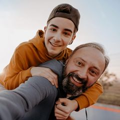 Sohn auf dem Rücken seines Vaters